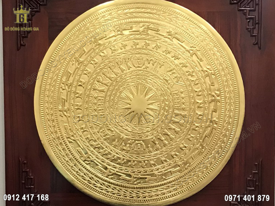 Nổi bật ở trung t&acirc;m mặt trống d&aacute;t v&agrave;ng l&agrave; h&igrave;nh ảnh ng&ocirc;i sao nhiều c&aacute;nh, đại diện cho mặt trời